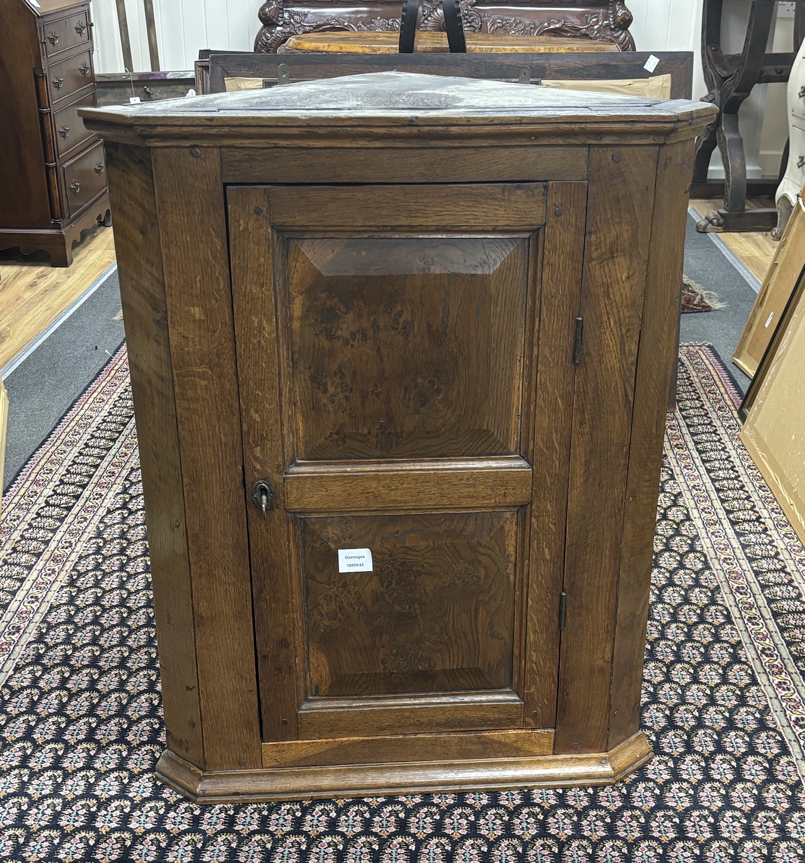 A late 18th century oak hanging corner cupboard, enclosed by a fielded panelled door, width 66cm, depth 38cm, height 85cm